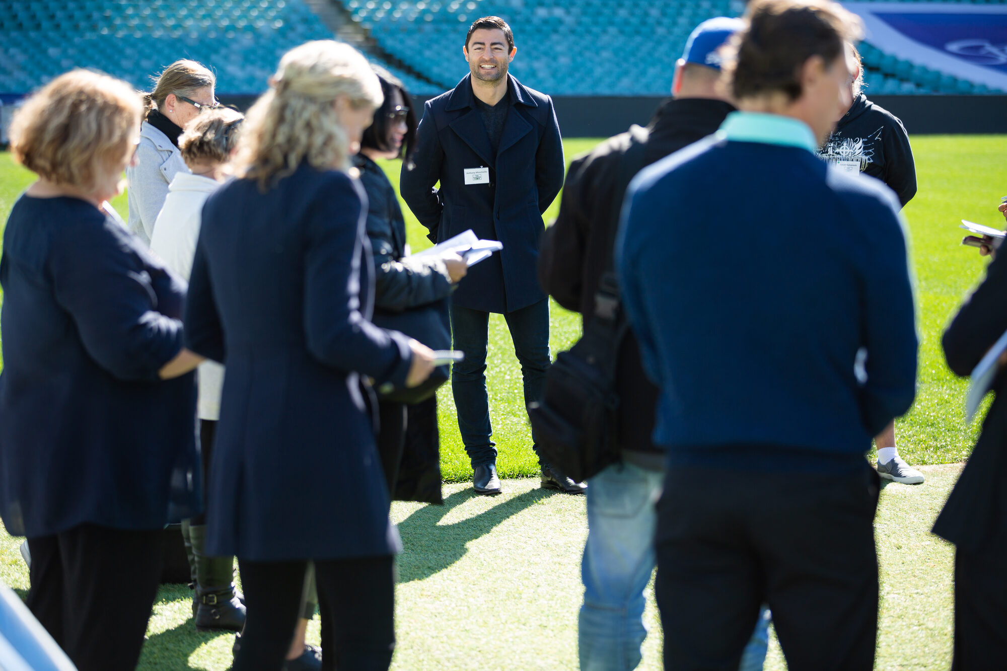 Anthony 'Mini' Minichiello on the field with participants either side during a Change Room Restore session